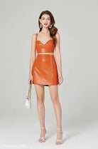 Orange faux leather two-piece set featuring an elegant leather set with zipper hip skirt