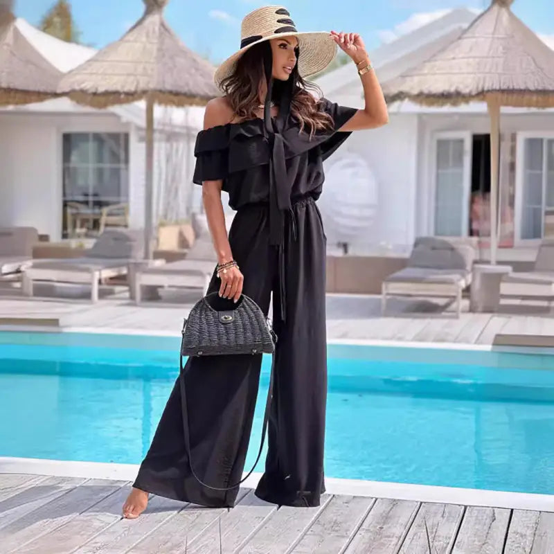 Woman in black shoulder jumpsuit and straw hat showcasing Elegant Off Shoulder Ruffle Jumpsuit