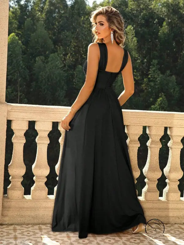 Woman in sexy thigh chiffon formal maxi dress on balcony, low back gown
