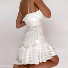White dress cotton with ruffles and spaghetti straps on a dark-skinned model
