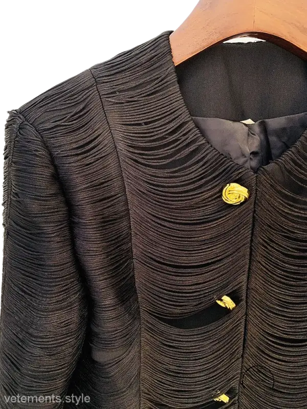 Textured black jacket with yellow rose-shaped buttons hanging on a wooden hanger, stylish tassel short jacket