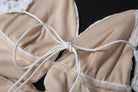 Lace-trimmed beige elegant slim fit evening dress with white tie and backless V-neck design