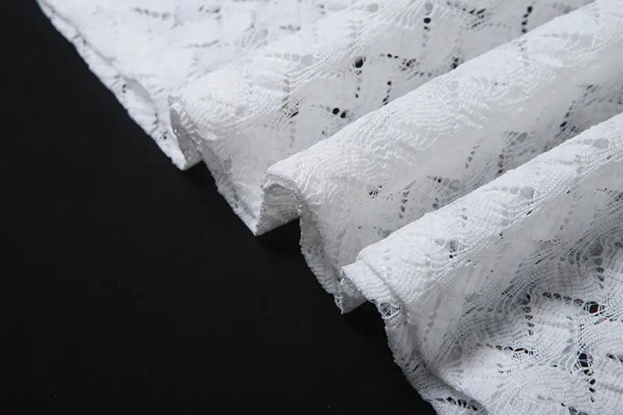 Delicate white lace fabric on an elegant slim fit evening dress with backless V-neck design