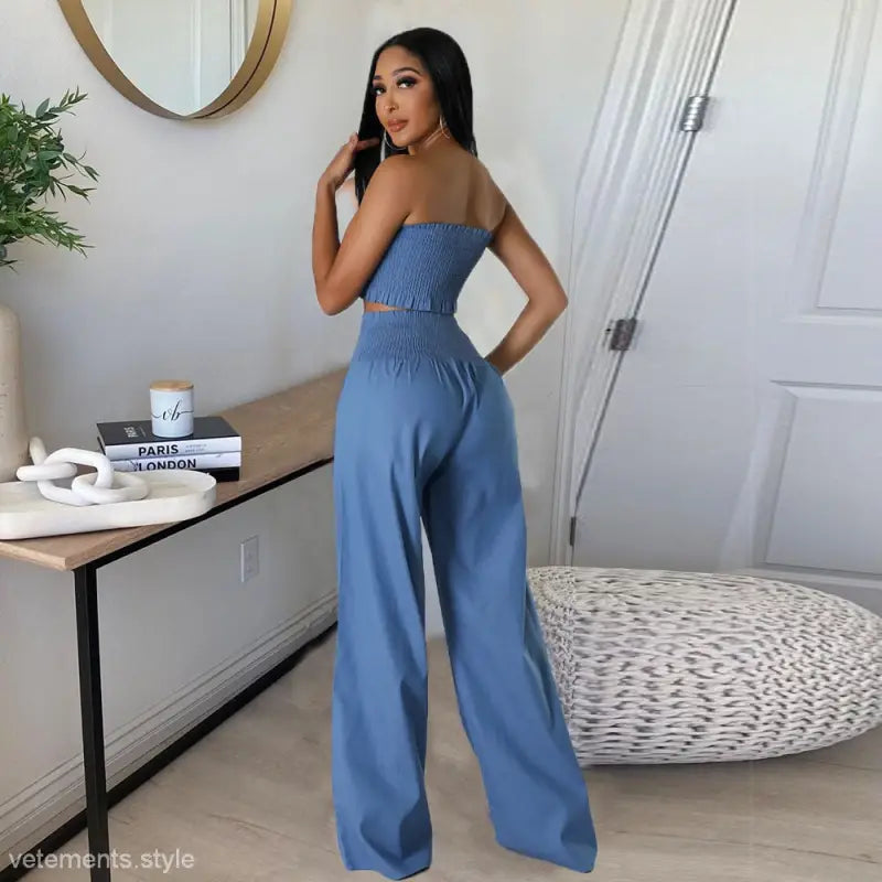 Woman in a blue sexy slim pants suit with ruffle and smocked strapless design