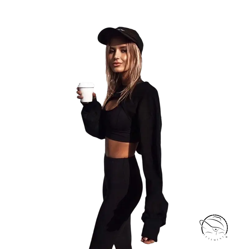 Woman in black athletic wear holding coffee, wearing fashionable fringes sweater