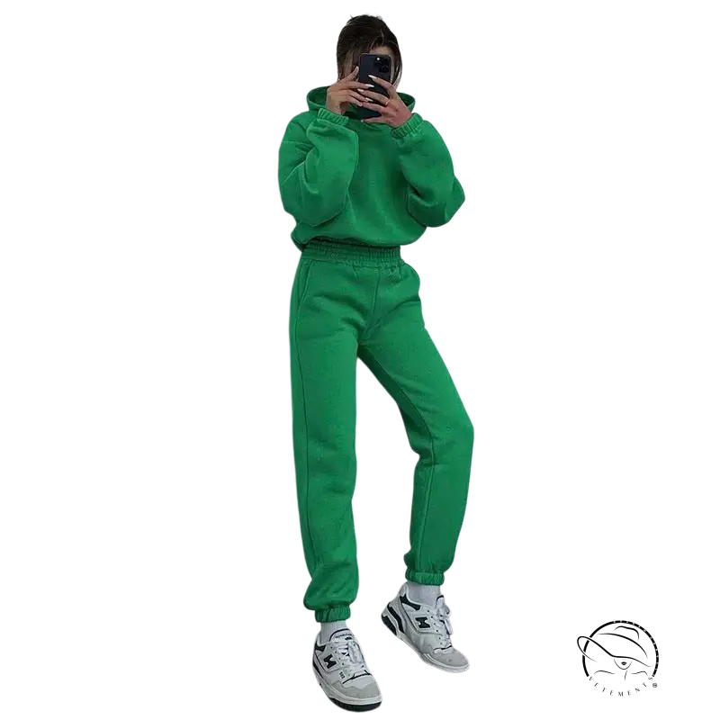 Person in hooded long sleeve sweater taking mirror selfie in white sneakers