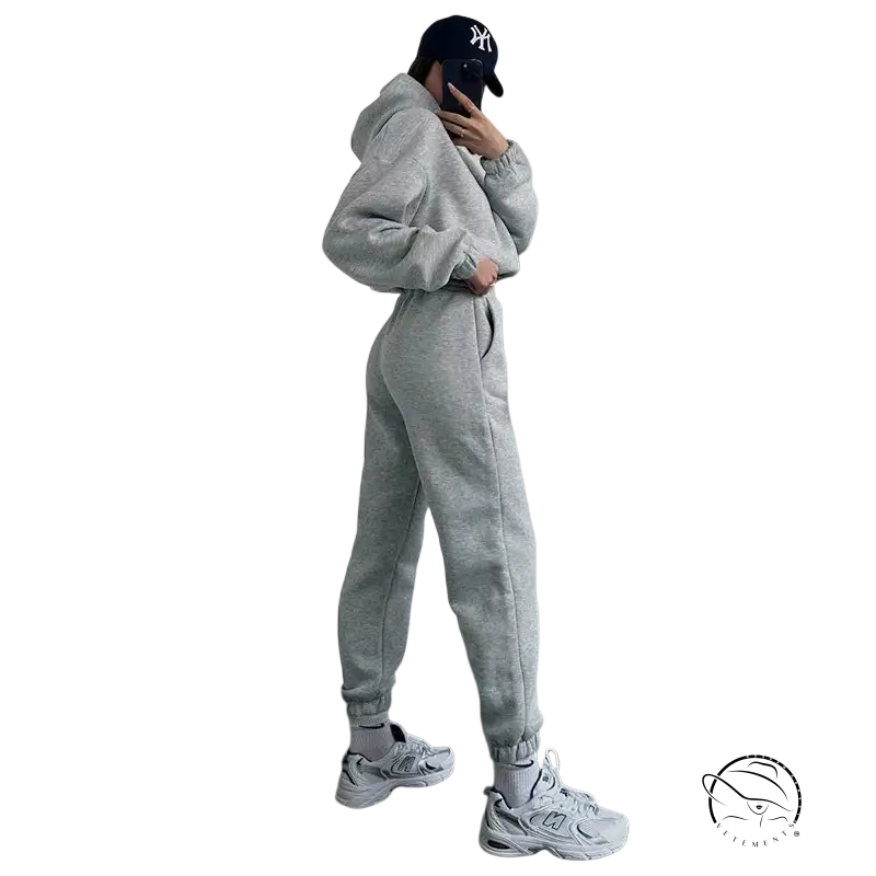 Person in gray hooded long sleeve sweater, Yankees cap, white sneakers