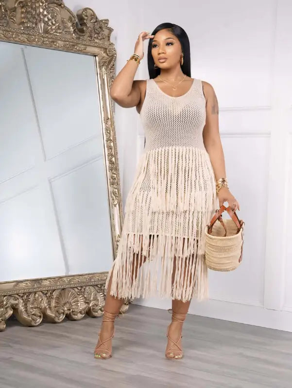 Woman in a light green knitted beach dress with elegant fringe detail for summer wear