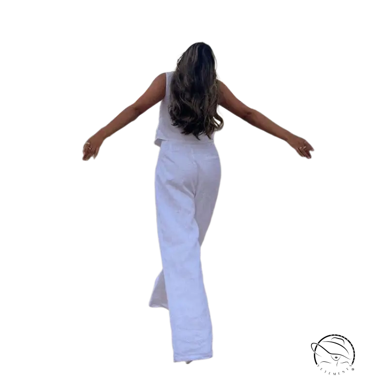 Woman in Monaco summer outfit walking on dirt path with arms outstretched