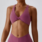 Mauve twisted-front sports bra in dark reddish purple and tropical orange for quick drying yoga