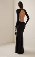 Elegant long black evening gown featuring a jeweled waist and an open back, perfect for parties
