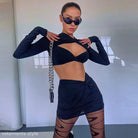 Woman wearing a sexy cutout long sleeve crop top in black, styled as a long sleeve dress