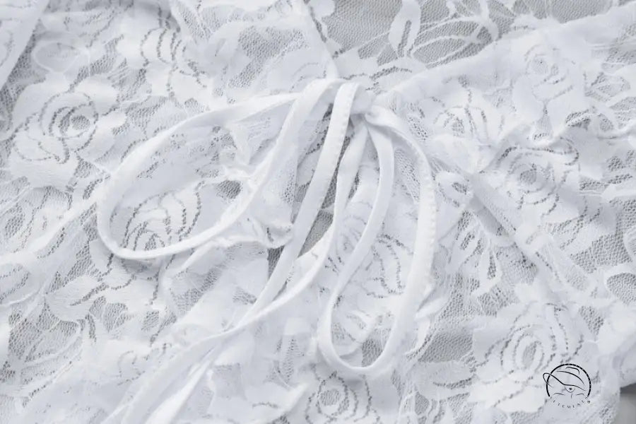 Delicate white lace sheath dress with floral pattern, ruffles and ribbon