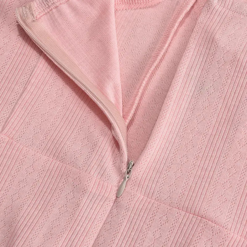 Pink textured fabric with a partially visible zipper.