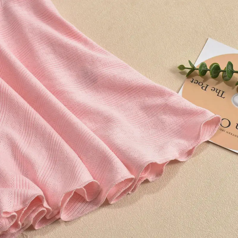 Soft pink fabric with delicate folds and a subtle pattern.