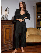 Woman in black silk home wear lounge set featuring a wide-legged jumpsuit and matching robe