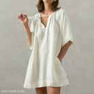 Loose-fitting soft cotton nightdress in off-white with pockets and tie sleeves in apricot