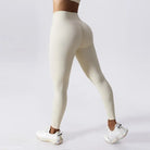 High-waisted cream athletic leggings paired with white sneakers for activewear style