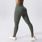 Olive green high-waisted athletic leggings paired with white sneakers, ideal for workouts