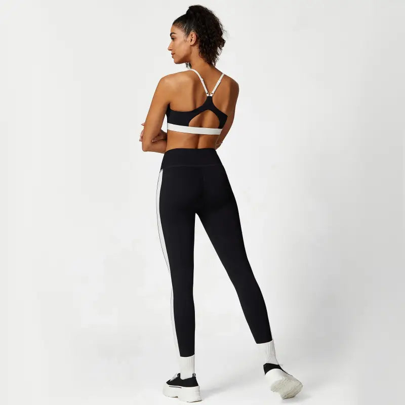 Woman wearing black athletic wear from Sporty Slim Nylon Color Block Cutout Set for waist hip lift