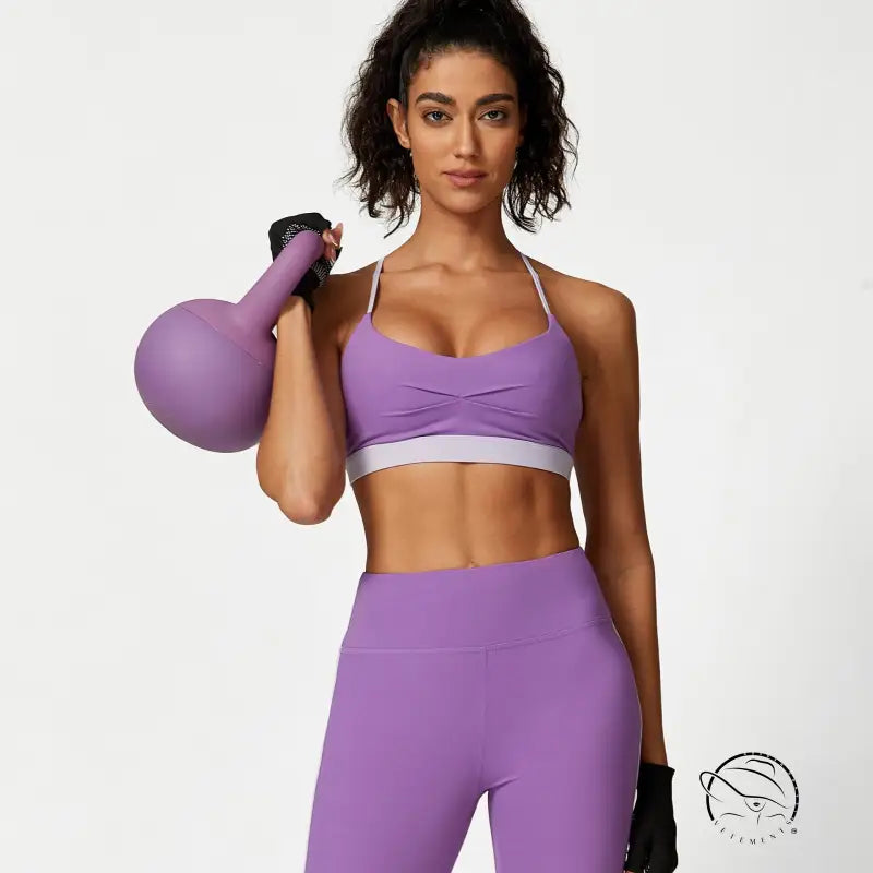 Woman in purple attire holding kettlebell for waist hip lift