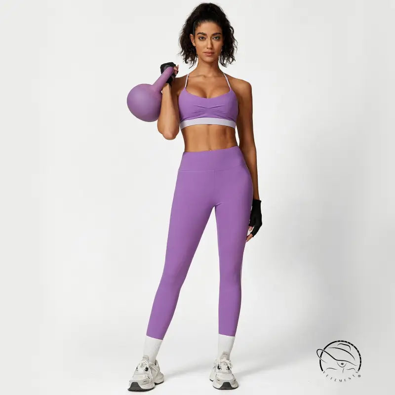 Woman in purple Sporty Slim Nylon set with waist hip lift holding kettlebell
